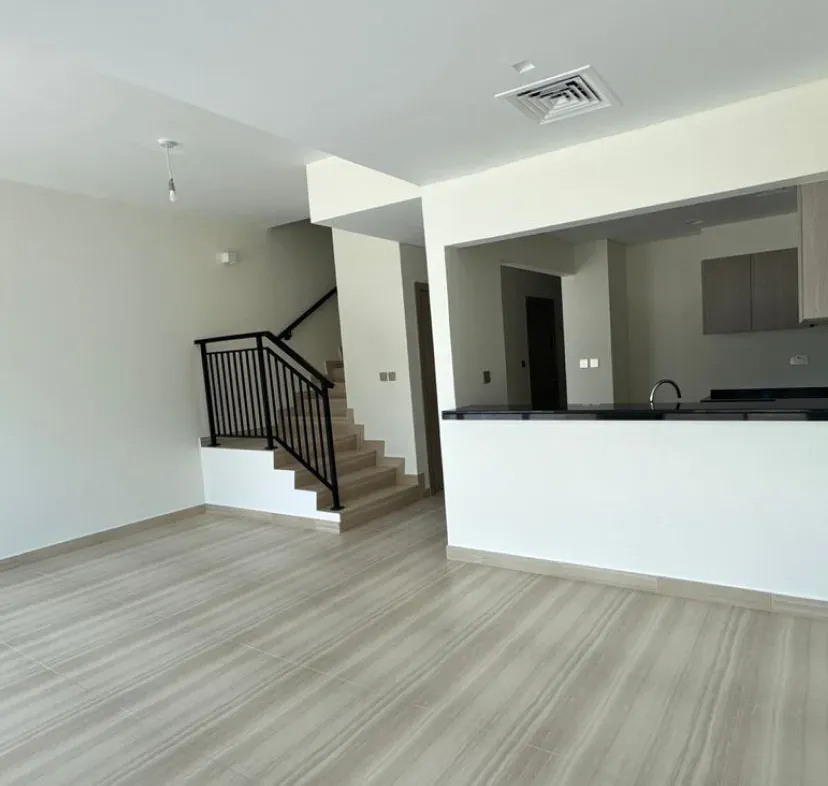 Open-concept interior with fresh neutral paint, wood-look flooring, and a staircase