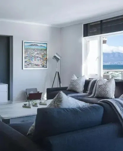 Restored living room with fresh grey walls and a sectional sofa by the window