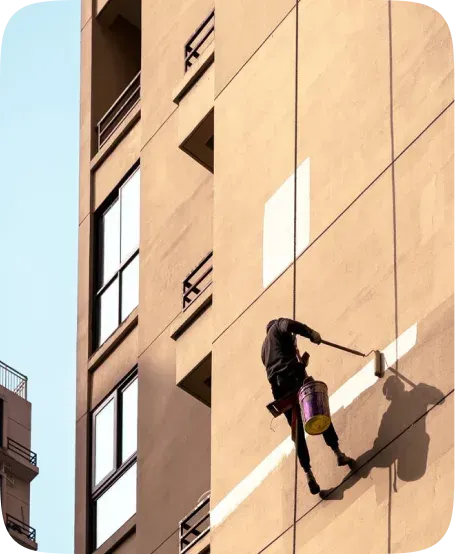 Painter on a rope repainting the exterior of a commercial building