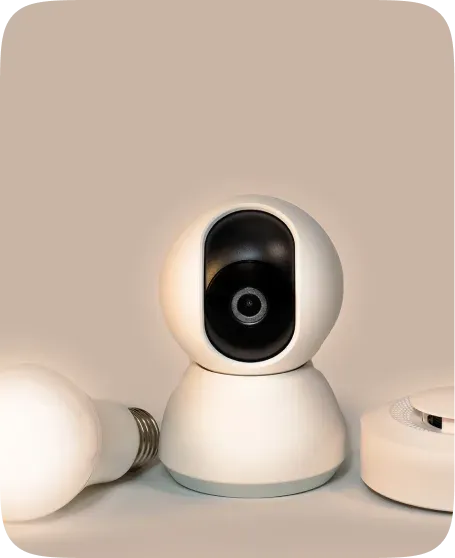 Smart home security camera beside a smart bulb and hub