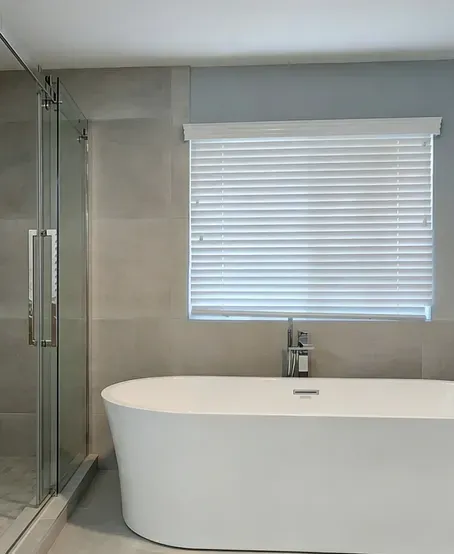Restored bathroom with a freestanding tub, glass shower and large-format tile