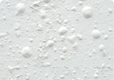 Close-up of paint bubbling on a textured wall surface